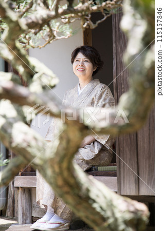 A woman in a kimono standing on the veranda 115157846