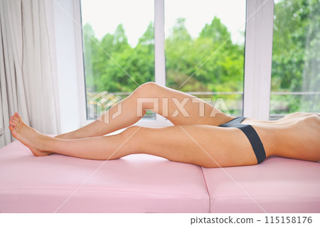 Woman body care. Close up of long female tanned legs with perfect smooth soft skin, pedicure, healthy nails on massage table. Epilation, beauty and health concept. Body care, depilation spa concept Woman body care. Close up of long female tanned legs with perfect smooth soft skin, pedicure, healthy nails on massage table. Epilation, beauty and health concept. Body care, depilation spa concept 115158176