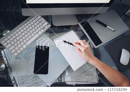 Unrecognizable woman hands writing in empty mock up notebook and computer. Freelancer using smart phone and laptop at home during quarantine. Unrecognizable woman hands writing in empty mock up notebook and computer. Freelancer using smart phone and laptop at home during quarantine. 115158299
