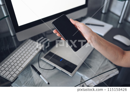 Female hands using smart phone in interior workplace, freelance business woman using cell phone at office desk, working from home using smart phone and notebook computer. Female hands using smart phone in interior workplace, freelance business woman using cell phone at office desk, working from home using smart phone and notebook computer. 115158426