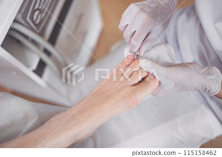 Professional medical pedicure procedure close up using nail clippers instrument. Patient visiting chiropodist podiatrist. Foot treatment in SPA salon. Podiatry clinic. Pedicurist hands white gloves Professional medical pedicure procedure close up using nail clippers instrument. Patient visiting chiropodist podiatrist. Foot treatment in SPA salon. Podiatry clinic. Pedicurist hands white gloves 115158462