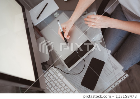 Workplace of photographer or graphic designer. Creative designer hands working on laptop with graphic tablet. 115158478