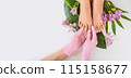 Beautiful perfect female skin legs feet top view with tropical flowers and green palm leaf. Nail polish, care and clean, spa pedicure treatment in white. Concept on background isolated. Copy space 115158677