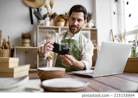 Mature man, potter, engaged in making home-made dishes and updating website. Mature man, potter, engaged in making home-made dishes and updating website. 115158994