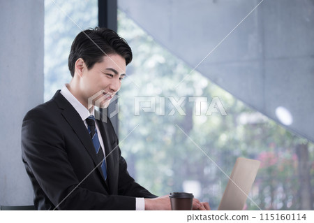 A businessman working in an office: A healthy smile and a positive image from the side; also good for job changes and recruitment A businessman working in an office: A healthy smile and a positive image from the side; also good for job changes and recruitment 115160114