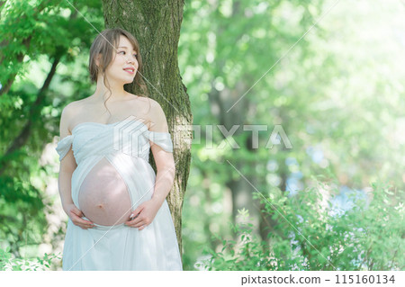 Asian pregnant women taking maternity photos (Sunlight filtering through foliage) Asian pregnant women taking maternity photos (Sunlight filtering through foliage) 115160134