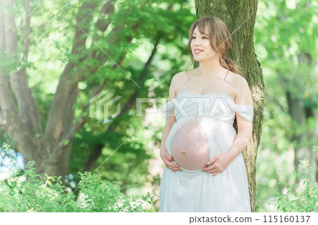 Asian pregnant women taking maternity photos (Sunlight filtering through foliage) Asian pregnant women taking maternity photos (Sunlight filtering through foliage) 115160137