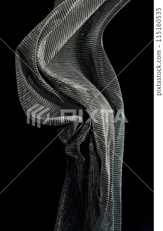 Silver drape fabric flying in curve shape, Piece of textile Silver drape fabric throw fall in air. Black background isolated motion blur 115160535