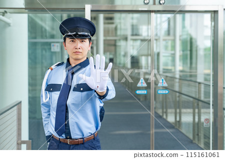 A security guard stops the entrance A security guard stops the entrance 115161061