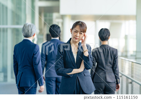 A middle-aged female business person who is worried about turning her back on her colleagues A middle-aged female business person who is worried about turning her back on her colleagues 115161150