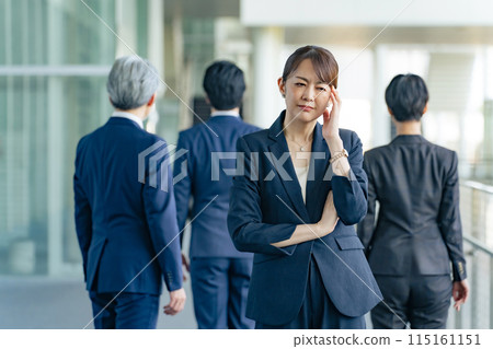 A middle-aged female business person who is worried about turning her back on her colleagues A middle-aged female business person who is worried about turning her back on her colleagues 115161151