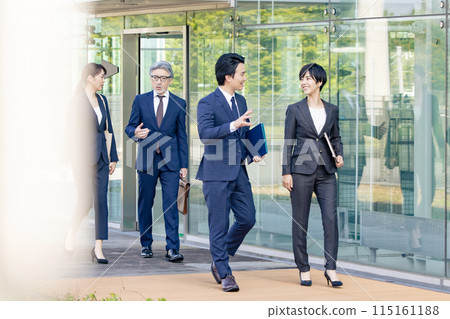 Group of business people walking in front of an office building 115161188