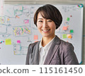 A female lecturer writing on a whiteboard 115161450