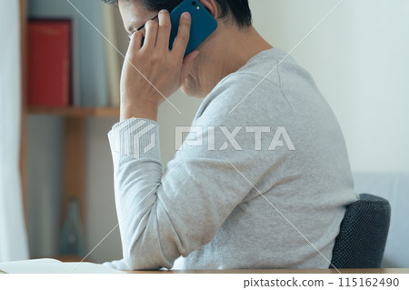 Middle-aged man talking on smartphone Middle-aged man talking on smartphone 115162490