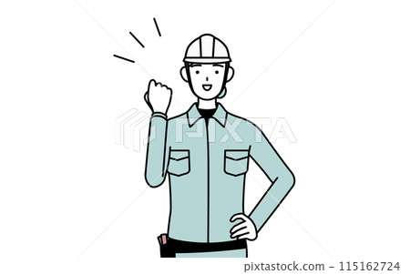 A female engineer in a helmet and work clothes making a fist pump 115162724
