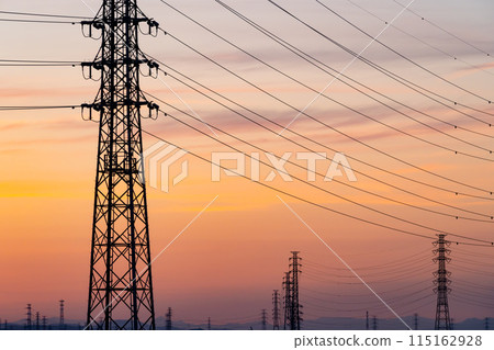 A row of power transmission towers and the sunset sky e-1 115162928