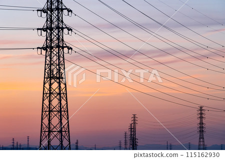 A row of power transmission towers and a sunset sky e-2 Cool colors 115162930