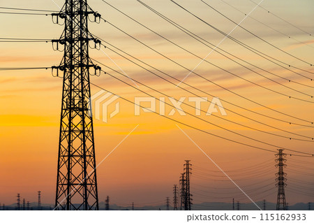 A row of power transmission towers and a sunset sky e-5 Warm colors 115162933