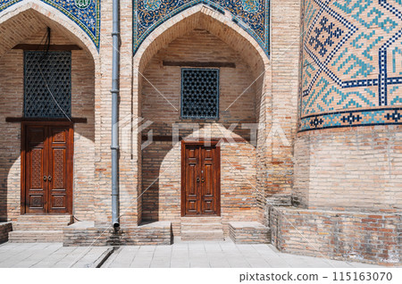 Uzbek carved wooden doors to Kukeldash Madrasah with pattern decorated with oriental arabic carved ornaments in Uzbekistan in Tashkent 115163070