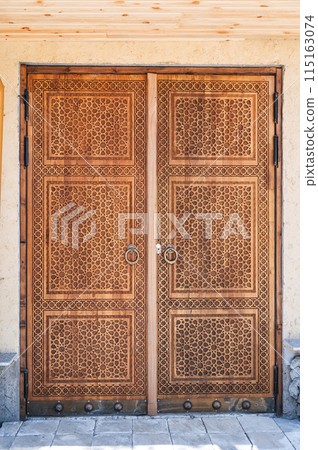 wooden door gate with a traditional oriental Uzbek carved pattern decorated with Islamic ornaments in Uzbekistan wooden door gate with a traditional oriental Uzbek carved pattern decorated with Islamic ornaments in Uzbekistan 115163074