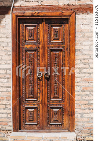 Uzbek carved wooden door to Kukeldash Madrasah with a traditional pattern oriental ornaments in Uzbekistan in Tashkent 115163076