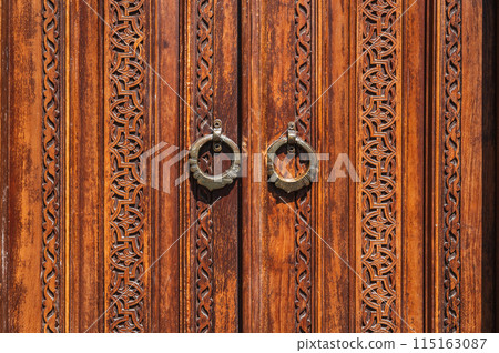 traditional oriental Uzbek Islamic patterns arabesque ornament on an wooden carved door in Uzbekistan close-up 115163087