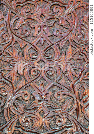 Oriental Uzbek Islamic kandakori patterns arabesque ornament on ancient wooden carved door in Uzbekistan close-up 115163091