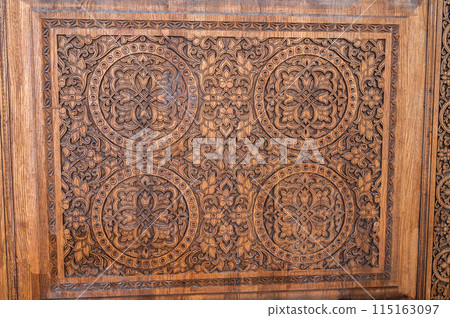 traditional oriental Tajik patterns arabesque ornament in kandakori bagdadi style on ancient wooden carved door in Tadjikistan 115163097