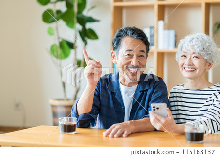 A senior couple looking at their smartphones together. A senior couple looking at their smartphones together. 115163137