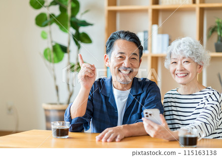 A senior couple looking at their smartphones together. 115163138