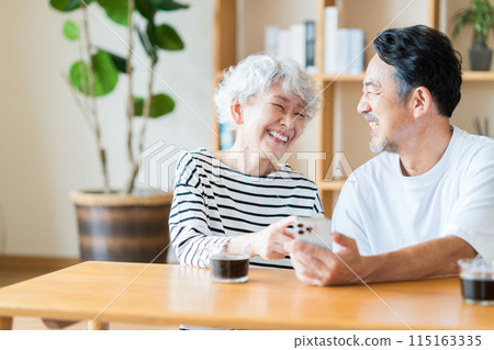 一對年長夫婦一起看他們的智慧型手機。 115163335