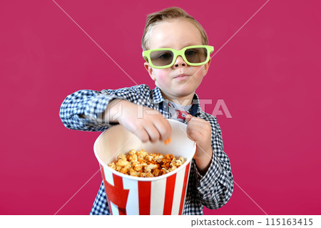 Cute fun kid baby boy 4 year old in red t-shirt holding bucket for popcorn Cute fun kid baby boy 4 year old in red t-shirt holding bucket for popcorn 115163415