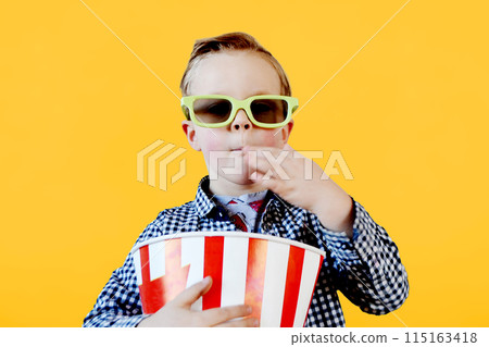 Cute fun kid baby boy 4 year old in red t-shirt holding bucket for popcorn 115163418