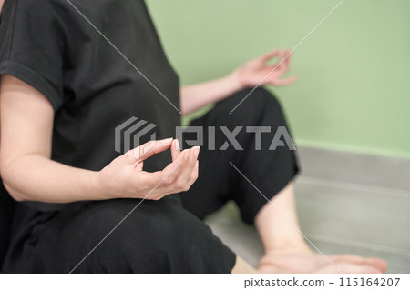 Yoga calm pose. Zen hand mudra. Lotus asana at studio training. Woman seating Yoga calm pose. Zen hand mudra. Lotus asana at studio training. Woman seating 115164207