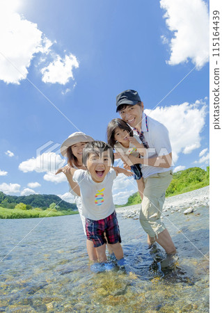 A family of four playing on a river in summer A family of four playing on a river in summer 115164439