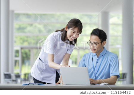 醫護人員和設施工作人員一邊看電腦螢幕一邊開會 115164482