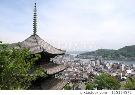 The three-story pagoda of Tennei-ji Temple and the streetscape of Onomichi City, Hiroshima Prefecture, seen from the approach to Senko-ji Temple. On the opposite bank across the Onomichi Strait is Mukaishima Island. The three-story pagoda of Tennei-ji Temple and the streetscape of Onomichi City, Hiroshima Prefecture, seen from the approach to Senko-ji Temple. On the opposite bank across the Onomichi Strait is Mukaishima Island. 115164572