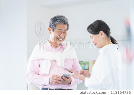 活躍的高級男女持有智慧型手機並進行對話 活躍的高級男女持有智慧型手機並進行對話 115164726