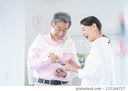 活躍的高級男女持有智慧型手機並進行對話 115164727