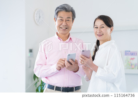 Active senior men and women with smartphones 115164736