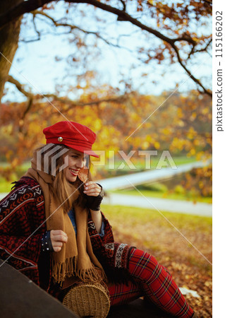 smiling elegant 40 years old woman in red hat with autumn leaf smiling elegant 40 years old woman in red hat with autumn leaf 115166202