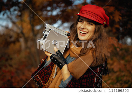 happy elegant woman in red hat with retro video camera happy elegant woman in red hat with retro video camera 115166203