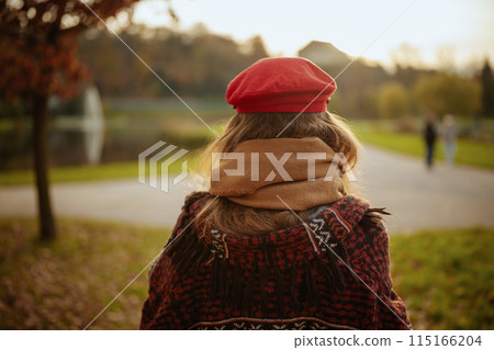 Seen from behind woman in red hat with scarf walking Seen from behind woman in red hat with scarf walking 115166204