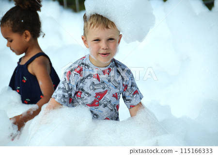 happy little boy with foam on his head, in wet clothes at a foam party happy little boy with foam on his head, in wet clothes at a foam party 115166333
