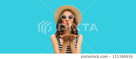 Portrait of beautiful young woman posing blowing kiss wearing summer straw hat on blue background Portrait of beautiful young woman posing blowing kiss wearing summer straw hat on blue background 115166916