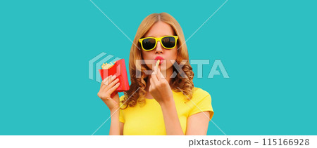 Portrait of stylish young woman eating french fries, fried potatoes fast food 115166928
