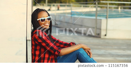 Portrait of stylish young african woman with dreadlocks posing wearing casual in the city 115167356