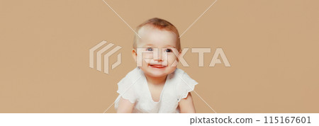 Happy cute baby crawling on the floor on brown studio background Happy cute baby crawling on the floor on brown studio background 115167601