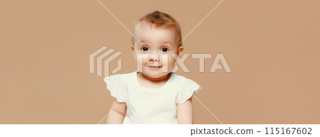 Happy cute baby crawling on the floor on brown studio background 115167602