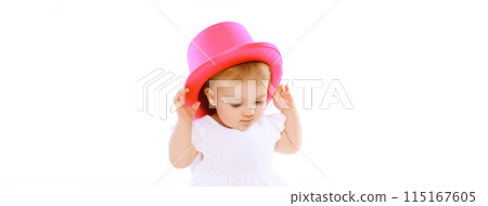 Cheerful baby playing with pink hat on the floor on white studio background Cheerful baby playing with pink hat on the floor on white studio background 115167605